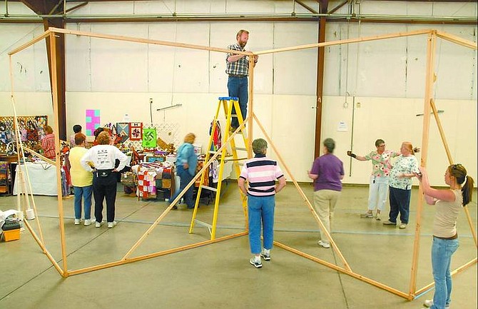 Kevin Clifford/Nevada Appeal Carson Valley Quilt Guild volunteer Jim Gibson, center, constructs support frames Friday morning to hang quilts for a quilt show this weekend at the Exhibition Hall in Fuji Park. This year&#039;s theme is &quot;Home Means Nevada&quot; and more than 100 quilts will be on display.