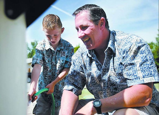 Chad Lundquist/Nevada Appeal Bob Martin works with his son David to wash his Jeep on June 11 at their home in Carson City. Martin has three children of his own and two stepchildren.