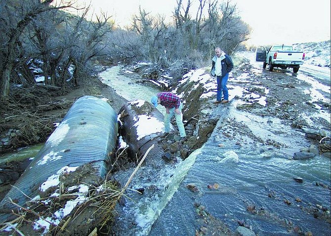 BRAD HORN/Nevada Appeal  Storey County Public Works Director Rich Bacus and county Commissioner Greg &quot;Bum&quot; Hess walk over a flooded portion of Six Mile Canyon Road that was damaged during the flood on Jan 4, 2006.