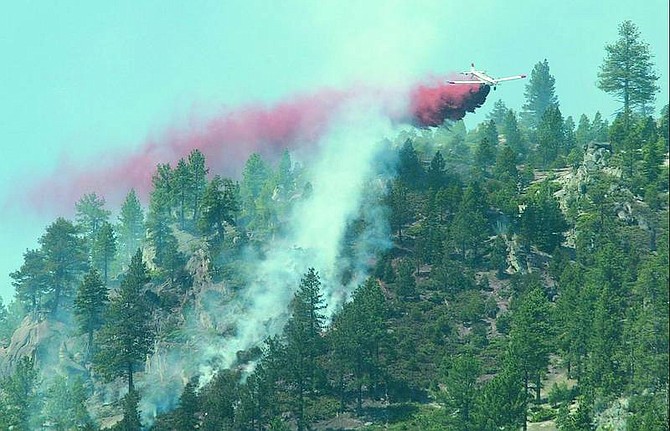Shannon Litz/Appeal News Service A plane drops fire retardant on a blaze on Jobs Peak Saturday morning. The fire began after a lighting strike Friday at about 4 p.m.