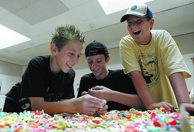 David, 12, Nathaniel, 12, and William, 12 laugh while working on a project at Dayton Community center Tuesday.