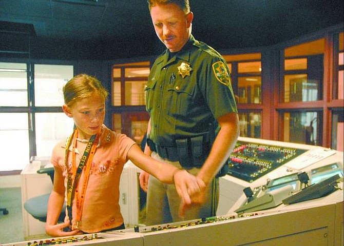 Kevin Clifford/Nevada Appeal Allison Gaskill, 9, opens doors at the jail command center Friday afternoon while being undersheriff for a day.
