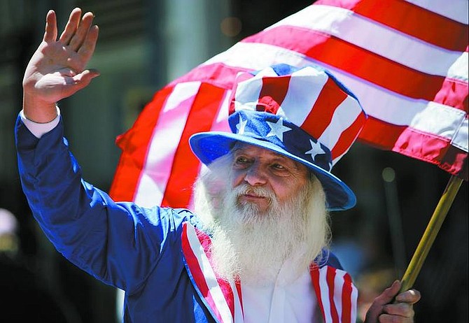 Chad Lundquist photos/Nevada Appeal Uncle Sam - aka Wilson - waves to the crowd from the back of a cherry-red Ford Mustang convertible Tuesday during the Virginia City Independence Day Parade.
