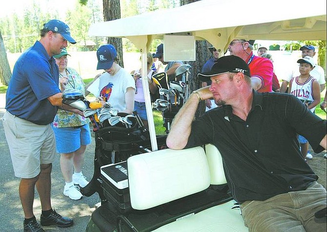 Dan Thrift/Tahoe Daily Tribune Trent Dilfer, right, waits while Chris Chandler finishes signing autographs Tuesday at hole 10 of Edgewood Tahoe Golf Course during practice for the American Century Championship.