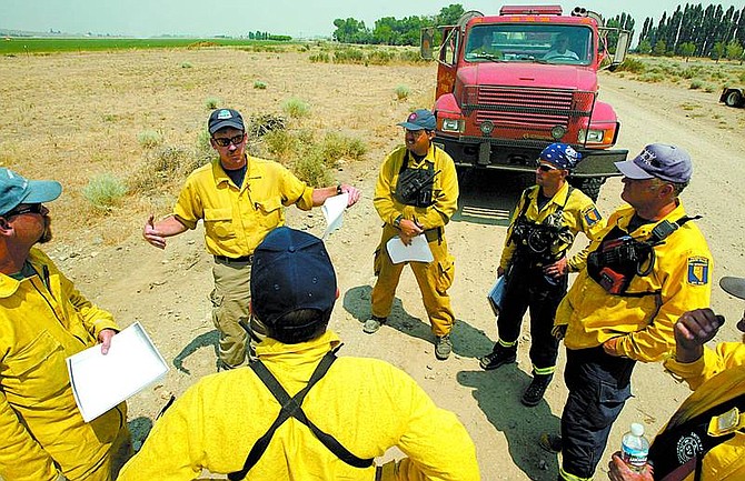 Shannon Litz/Appeal News Service Darren Swinney briefs a crew Tuesday from the Yerington Mason Valley Fire Department on the Jackass Flat fire and possible structure protection on Desert Creek Road. The fire, which started Monday, is burning seven miles south of Wellington near the Douglas and Lyon county line.