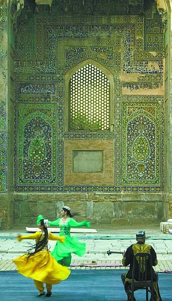 Rick Gunn/For the Appeal A musician plays for dancers outside the Registan in Samarkand. The intricate tile work serves as a dedication to Allah.