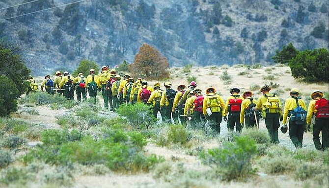 Chad Lundquist/Nevada Appeal A firefighting crew from North Carolina braves steep terrain Sunday afternoon to help establish fire lines near Sugarloaf Mountain during the Six Mile fire.