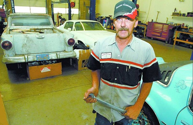 Shannon Litz/Nevada Appeal News Service Robert Hadfield with a Ranchero, a Camero and a Firebird in his garage at Insane Customs Performance &amp; Automotive Repair in Gardnerville. Hadfield, who moved his family to Carson City and opened the shop last spring, will attend his first Silver Dollar Car Classic and Hot August Nights today.