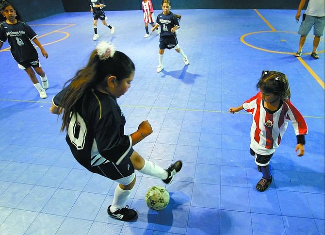 Chad Lundquist/Nevada Appeal Puma forward Brisieda Lozano, 9, left, battles with Yanitzia Perez, 6,  of the Chivas&#039;s during Wednesday&#039;s game at the Carson indoor soccer league arena.