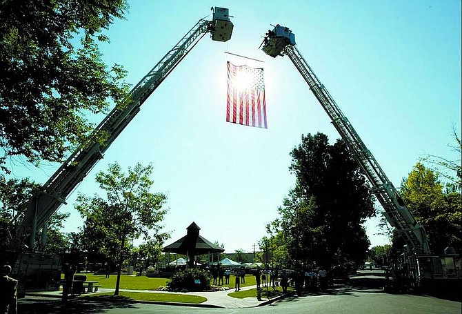 Shannon Litz/Appeal News Service Two ladder trucks hoist an American flag at the corner of Sixth Street and Mono Avenue in Minden on Friday morning for the memorial service of State Sen. Lawrence Jacobsen.