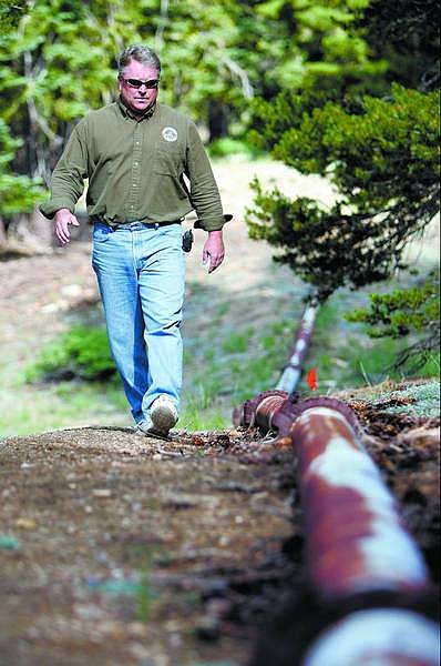 Chad Lundquist/Nevada Appeal Mike Leahy, water systems manager for the State of Nevada, walks a section of pipe between Marlette Lake and Hobart Reservoir. The state laid the pipe in 1963 from Marlette over the crest of the mountain and down the hill toward Hobart Reservoir.