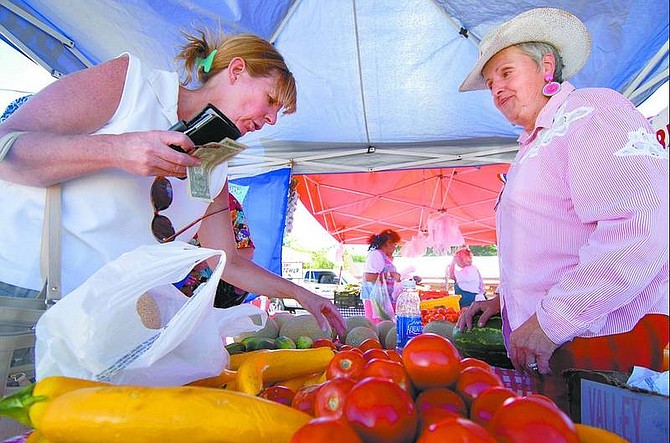 Kevin Clifford/Nevada Appeal Leslie Irwin, left, of Dayton, looks at Maria Masini&#039;s produce Thursday evening during the Dayton Farmers Market at the Community Roots nonprofit nursery.
