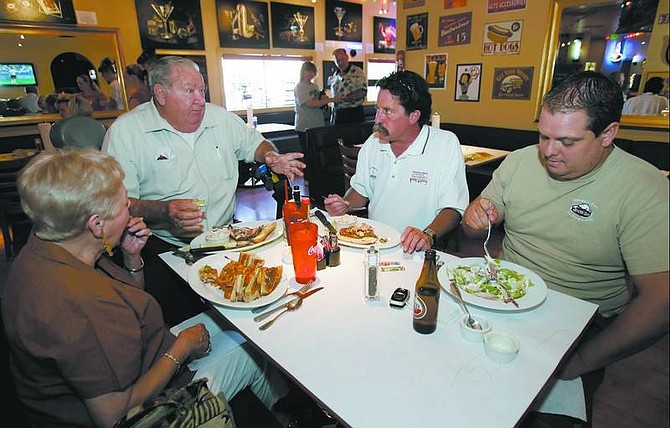 Photos by Chad Lundquist/Nevada Appeal Gilda Harrall, from left, Curly Harrall, Bob Williams and Mark Johnson eat lunch at Dick&#039;s Winghouse Sports Bar on Wednesday. The Mound House restaurant recently changed names and decor.