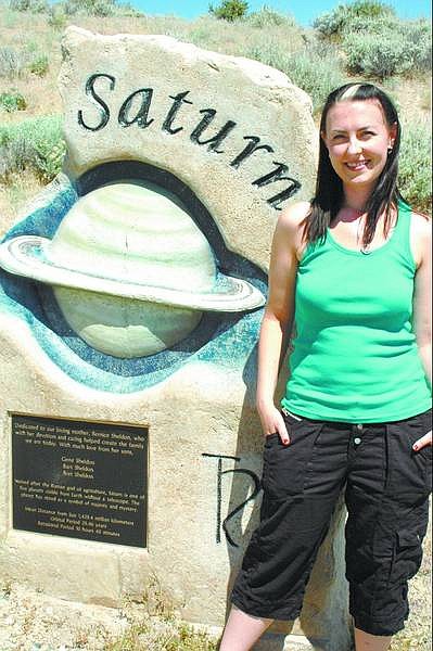 Former Western Nevada Community College student Amanda Heidermann stands next to the sandstone sculpture of Saturn on the college&#039;s  Planetary Walkway that connects the main campus to the Jack C. Davis Observatory. Heidermann is working toward a doctorate in astronomy.  Submitted Photo