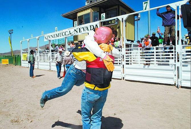 Nevada Commission on Tourism photo Ken Robins, owner of a building-renovation company in New York, embraces his &quot;Nevada Passage&quot; teammate Gina DeTolve, a project engineer from Valencia, Calif., after she earned the longest time on the bucking range cow. Her time of 4.3 seconds placed the team of developers in the lead. Athletes covered 1,000 miles visiting six rural spots in Nevada as part of the second annual made-for-television adventure competition.