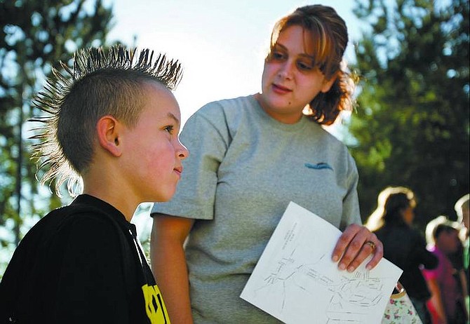 Chad Lundquist/Nevada Appeal Brice Bachler, 6, listens to his mom, Valerie, on Monday as she tells him which bus he needs to take home from the first day of school at Dayton Elementary.