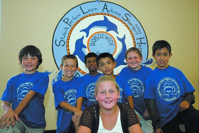 Chad Lundquist/Nevada Appeal Left to right, Charley Hersey,10, Justin Whitehead, 9, Jason Reynolds, 10, Damien Munoz, 8, Reid Williamson, 11, Jose Herrera, 11,  and Morgan Barton, 10, sit in front of the logo at Bordewich-Bray Elementary School. Students earn T-shirts with the new &quot;Splash&quot; logo, designed by Barton, by performing good deeds or making improvements in school. The students pictured were the first to earn shirts at the school.