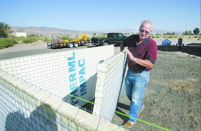 Cathleen Allison/Nevada Appeal Ron Bell works on a retaining wall at his Silver Springs home Thursday. Bell is using welded wire sandwich panels, which are made of recycled materials and offer more energy efficiency.