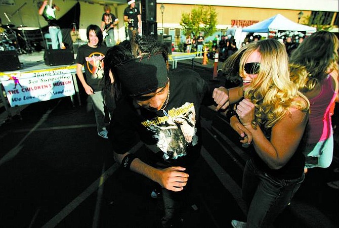 BRAD HORN/Nevada Appeal Sami Busey, 16, moshes with Raul Castro, 14, during Civica&#039;s set during the Jester&#039;s Joust Battle of the Bands in the Carson Nugget west parking lot on Saturday.