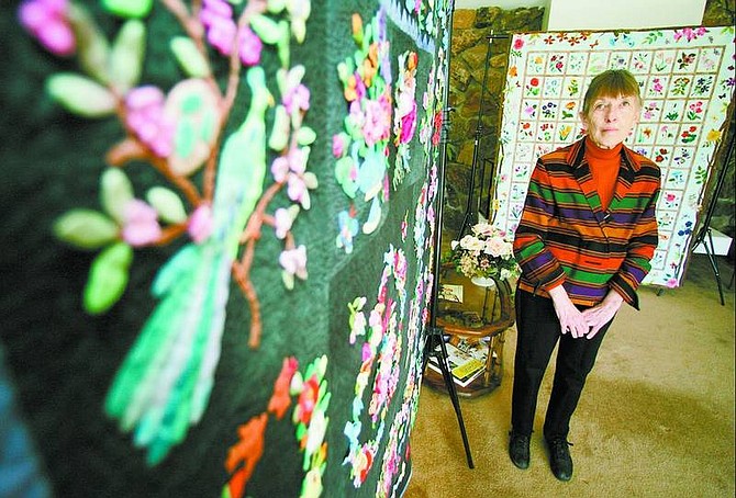 BRAD HORN/Nevada Appeal Carolyn Susac stands in between The Blossoms of Baltimore, left, and Summer&#039;s Jewels, in her Reno home on Wednesday. Susac will be teaching a class during a quilt show in Silver Springs in October.
