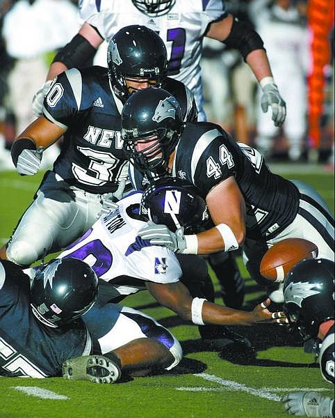 Nevada defenders, Joshua Mauga (30), Jeremy Engstrom (44) and Matt Hines (57) force Northwestern&#039;s Tyrell Sutton to fumble in the first quarter on Friday&#039;s game, Sept. 22, 2006 in Reno, Nev. Nevada won 31-21. (AP Photo/Cathleen Allison)