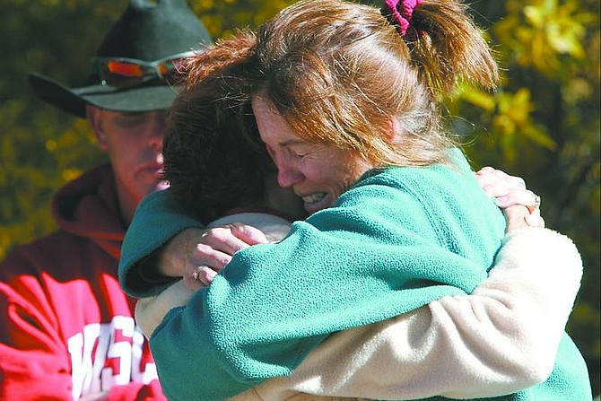 Linda McConnell/Rocky Mountain News Wendy Mersinger, right, hugs neighbor Lisa Turnbull in front of Turnbull&#039;s brother Steve Neevel, Thursday, in Bailey, Colo. The day after a gunman held students hostage at Platte Canyon High School, killing Emily Keyes, authorities said, community members gathered to console each other at Platte Canyon Community Church.