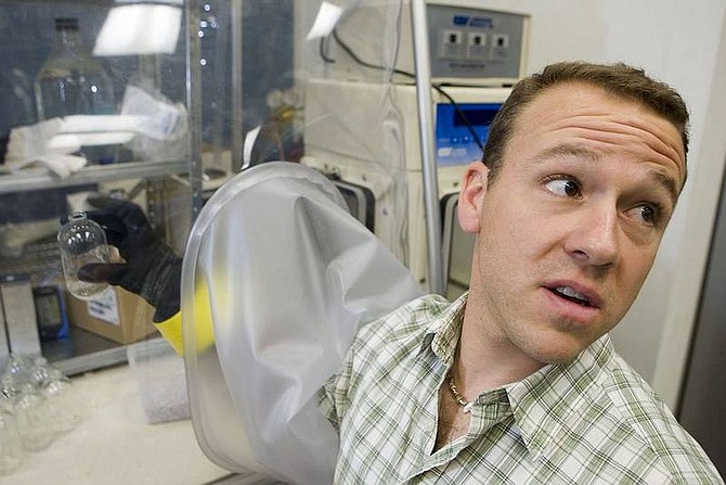 Clint Karlsen/Las Vegas Review-Journal University of Nevada, Las Vegas, microbiologist and assistant professor Brian Hedlund handles a vial in an anaerobic chamber, which is used to house organisms that can survive only in certain environments, in his lab Sept. 27 in Las Vegas.