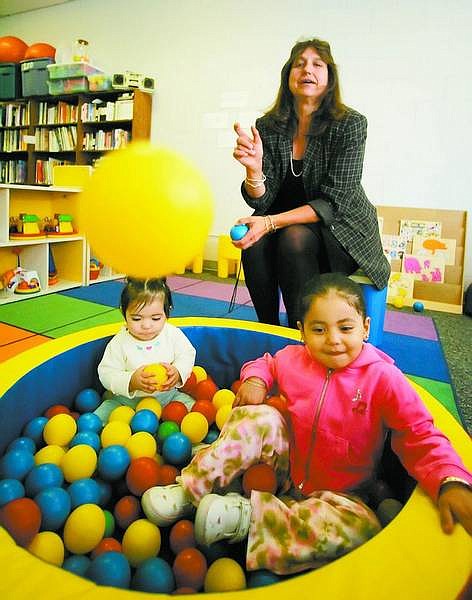 BRAD HORN/Nevada Appeal Joyce Buckingham plays with Martina Gutierrez, 9-months, and her sister Kendra, 3, at the Ron Wood Family Resource Center in Carson City on Thursday. Buckingham is the new director at the center.
