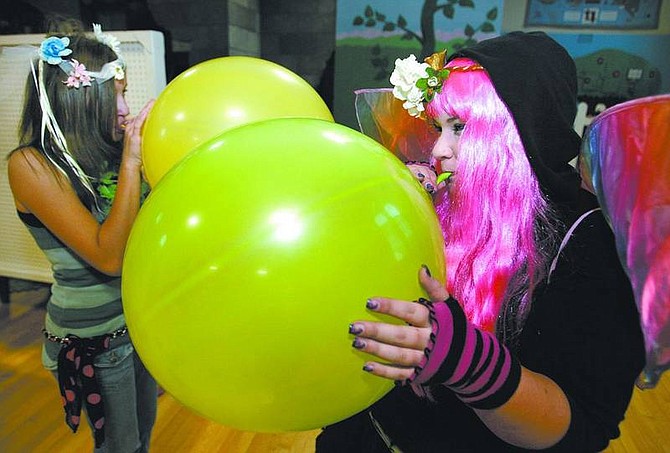 Cathleen Allison/Nevada Appeal Volunteers Angela Sanders, 13, left, and Kristin Stanford, 15, inflate balloons for the Halloween teen dance at the Children&#039;s Museum of Northern Nevada on Friday night. Experts recommend teens be given responsibility to avoid getting into trouble on Halloween.