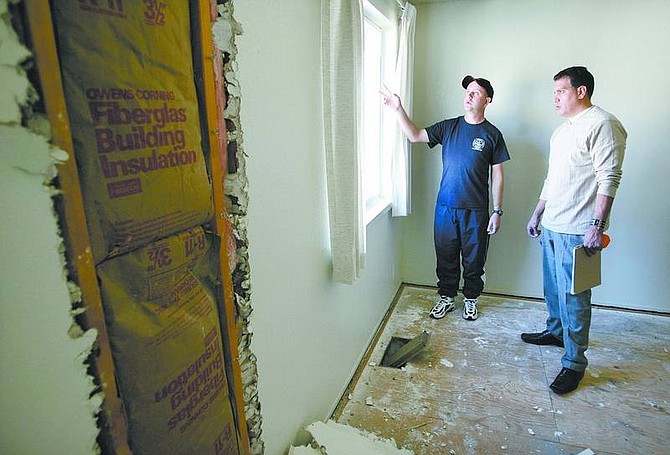 Cathleen Allison/Nevada Appeal Bill Baker, left, talks with Eric Govan, of Sparks Glass, on Wednesday. Baker is renovating the Carson City town house he recently purchased using an $8,200 down payment covered by a state grant.