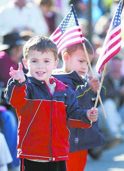 Cathleen Allison/Nevada Appeal Max Gonkel, 3, waves at the Douglas High School Marching Band while watching the parade Saturday with his cousin Jade Earle, 3, both of Carson City.