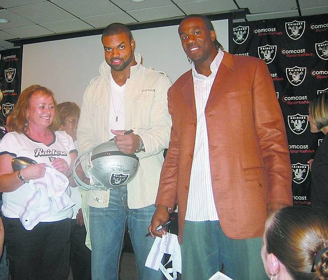 PHOTO BY ANN YUKISH-LEE Carson City Raiders Booster Club member Paulette Patay, left, gets autographs from Oakland Raiders players Grant Irons, center, and Sam Williams recently at the Raiders Football 101 Workshop for Women.