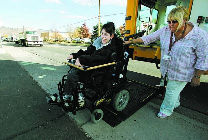 Jared Dempsey is helped off a Carson City School District bus by the driver on Koontz Drive on Wednesday.   BRAD HORN/ Nevada Appeal