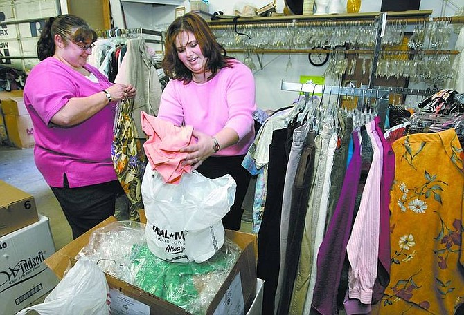 Cathleen Allison/Nevada Appeal Kim Farrow, left, and Traci Trenoweth, with the Advocates to End Domestic Violence, sort through donated clothing at Classy Seconds Thrift Store on Wednesday afternoon. The &quot;Women to Work&quot; clothing drive is held twice a year to help women re-enter the work force with professional clothing.