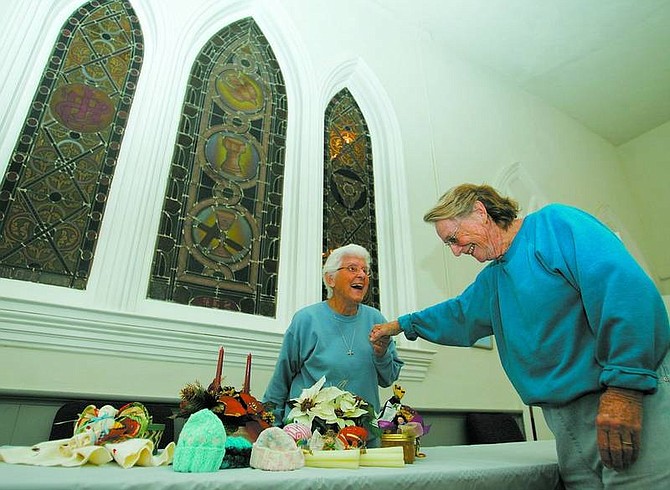Mary Wulkau, left, and Sandy Groff set up crafts and gifts for the Christmas bazaar at St. Peter&#039;s Episcopal Church on Wednesday. BRAD HORN/Nevada Appeal