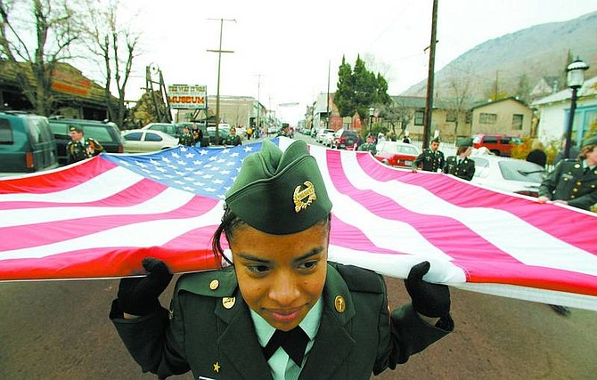 BRAD HORN/Nevada Appeal Wendy Tapia of Incline High School&#039;s ROTC helps carry the American flag down the main street in the Virginia City Veterans Day parade on Saturday.