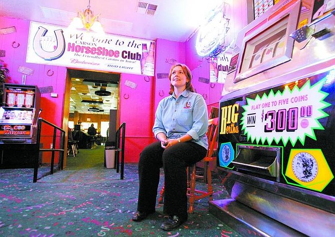 BRAD HORN/Nevada Appeal Jeanette Kelley, general manager of the Horseshoe Club, sits near a 30-year-old slot machine that is under repair while at the casino on Friday.