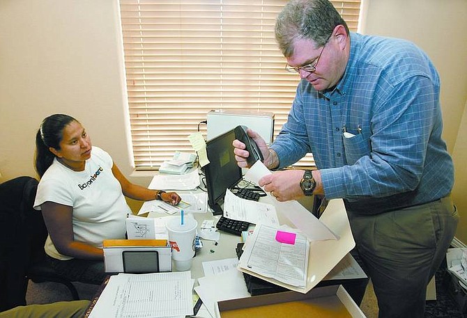 Cathleen Allison/Nevada Appeal Tansey Anderson completes move-in paperwork with Dolphin Bay Luxury Apartments manager Craig Morris on Friday morning. The Anderson family is the first to move into the 132-unit complex in North Carson City.