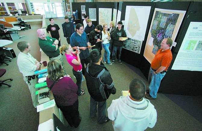 BRAD HORN/Nevada Appeal Danielle Judge, 17, photographs Grahame Ross, a GIS Analyst for the Nevada Department of Transportation, during the engineering fair at Carson High School on Friday. Judge is in a GIS II class at the school and is creating a project from the fair.