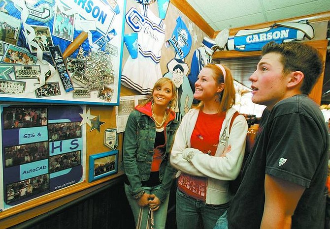 BRAD HORN/Nevada Appeal Carson High School students from left, Kelsey Dockery, 16; Molly Champion, 17; and Bryan Byrne, 16, helped decorate a wall in Applebee&#039;s Neighborhood Grill &amp; Bar with Carson High School memorabilia. The juniors are in leadership roles with the C-Unity student pride group at the school.