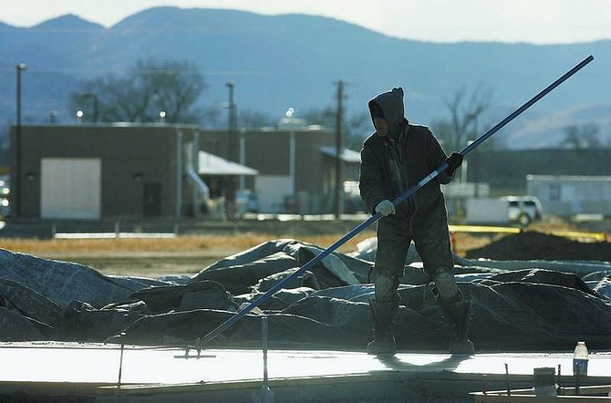 Chad Lundquist/Nevada Appeal A construction worker smoothes concrete at the site of the new elementary school in the Riverpark development in Dayton on Tuesday. The new school is located east of the Rolling A Wastewater Treatment plant.