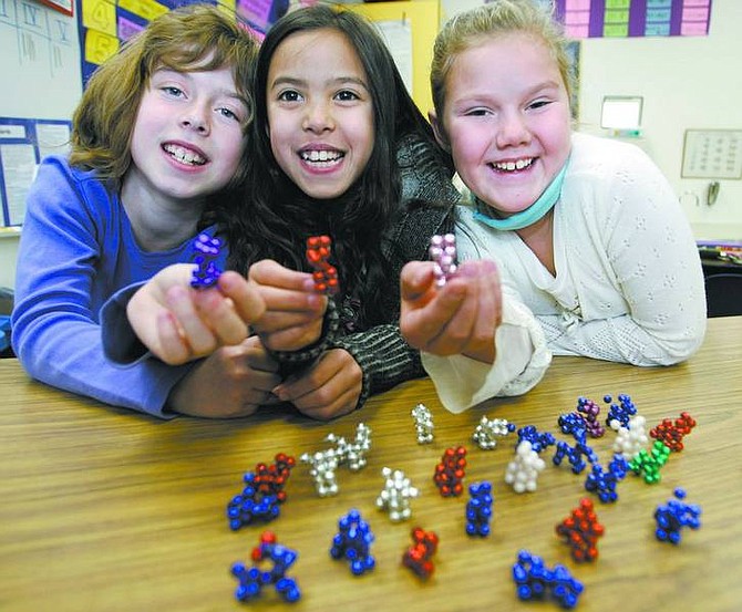 Cathleen Allison/Nevada Appeal Mari Hunt, Amber Riggins and Logan Wilmouth, all 9, have been making and selling bead dogs as part of Helping Hands, a Dayton Elementary School holiday fundraiser.