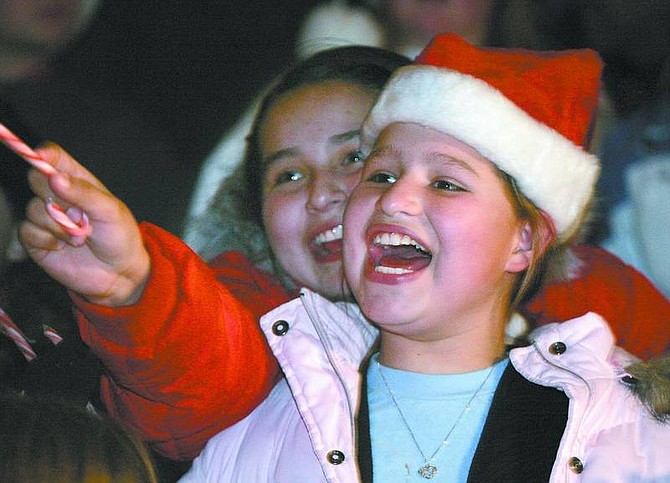 Cathleen Allison/Nevada Appeal Fritsch Elementary students Makayah Colunda, 10, left, and Danielle Bennett, 11, look for friends and family in the crowd at the Silver &amp; Snowflakes Holiday Tree Lighting ceremony at the Capitol on Thursday night.