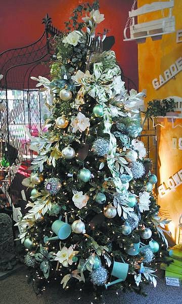 Chad Lundquist/Nevada Appeal  An array of bulbs, watering cans and flowers give this tree an expansive look, with the colored lights adding accents. Prices for the Greenhouse Garden Center artificial trees depend on the decorations selected.