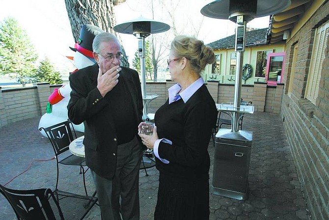Cathleen Allison/Nevada Appeal Carson City Mayor Marv Teixeira talks with Glen Eagles Restaurant owner Kris Fiegehen on the patio Friday afternoon. Teixeira and other Nevada smokers are banished to the outdoors after a voter-approved smoking ban took effect Friday.