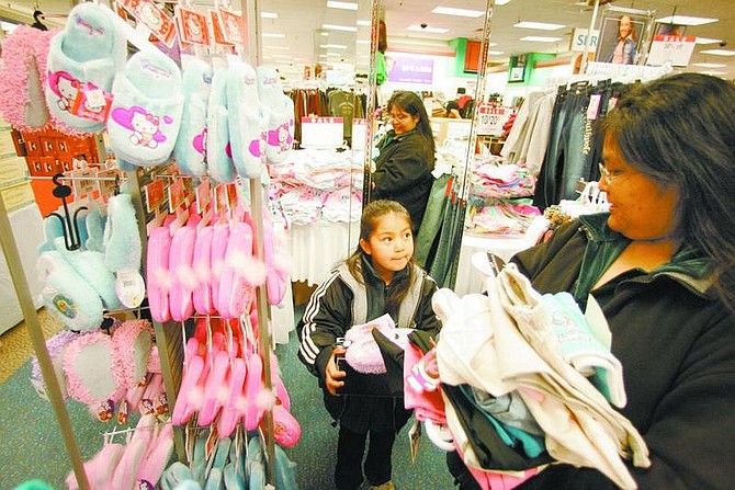 BRAD HORN/Nevada Appeal Tristen Dressler, 7, picks out slippers with her mother, Lovana, during the Childspree shopping spree at Mervyns on Saturday morning. Tristen&#039;s family is from the Woodfords Washoe colony.