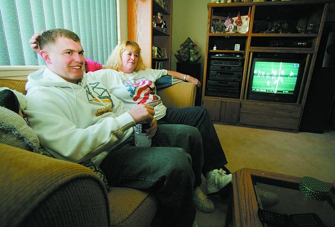 BRAD HORN/Nevada Appeal Cpl. Mike DeWitt Jr., of the 3rd Marine Logistics Guidance, watches football with his mother Carla McClelland in her Carson City home on Sunday. DeWitt hasn&#039;t been home in two years.
