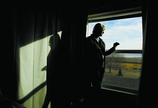BRAD HORN/Nevada Appeal June Mick looks out her bedroom window at the train tracks the Energy Department is studying as a possible rail line to transport nuclear waste to Yucca Mountain. Mick moved to Silver Springs from south Florida with her husband six month ago.