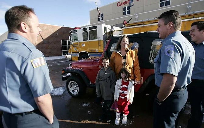 Chad Lundquist/Nevada Appeal Marcie Odem and her children, Braden, 7, and Riley, 4, stand in front of the Jeep Wrangler Odem won in a Carson City Fire Department raffle. Odem and her family moved from Gulfport, Miss., following Hurricane Katrina.
