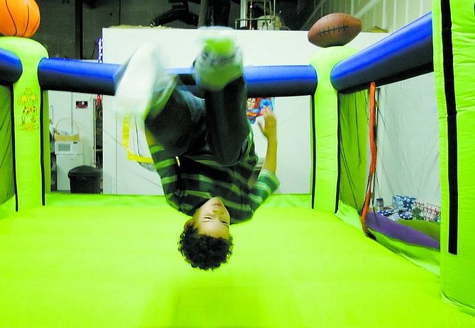 Brad Horn/Nevada Appeal Julius Estrada, 6, of Carson City, does a back flip in a bounce castle during a Christmas party at Bouncerz on Friday. Carson High School&#039;s National Honor Society raised money and bought gifts for six Carson City families and threw a Christmas party for them.